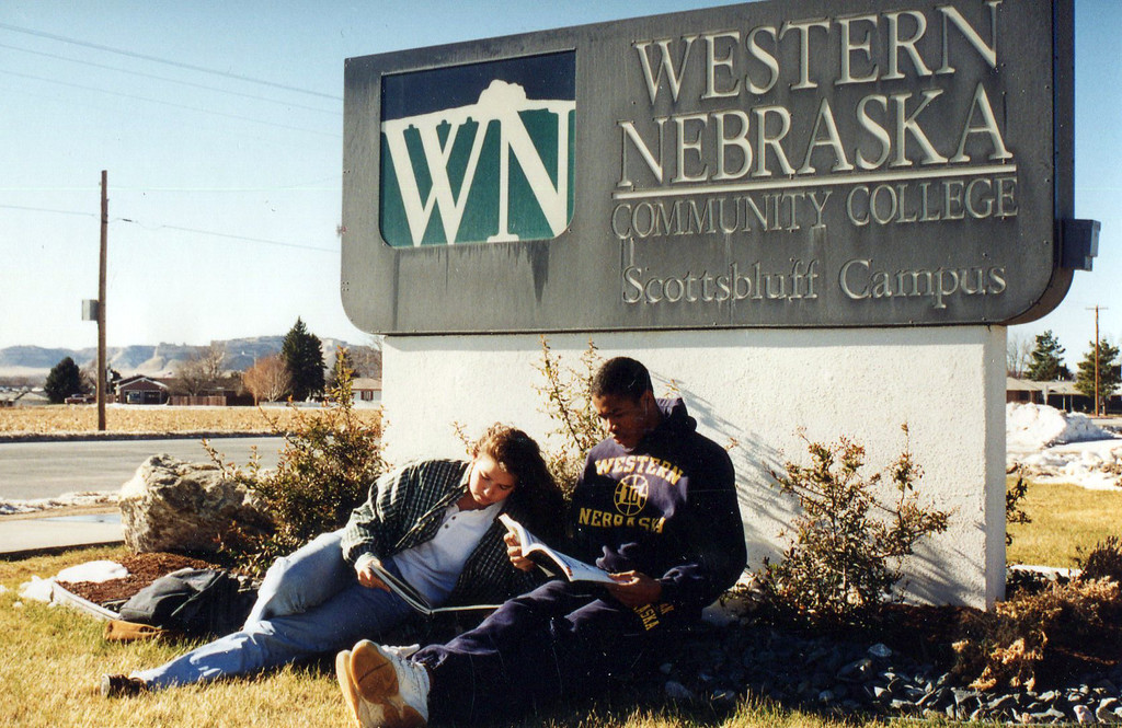 students sitting in front of Western Nebraska Community College sign