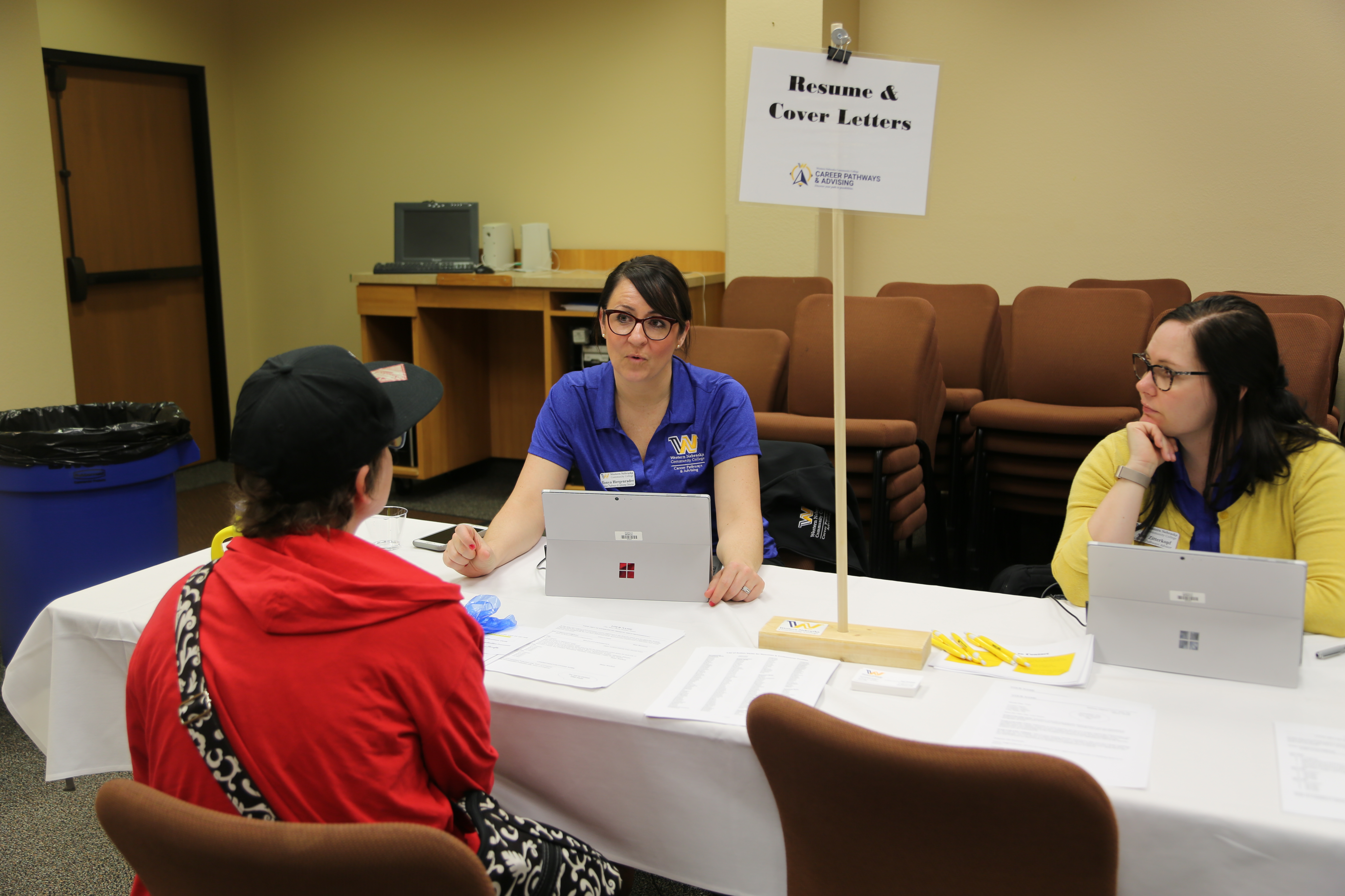 Career pathways advisor helping students at a job fair. 